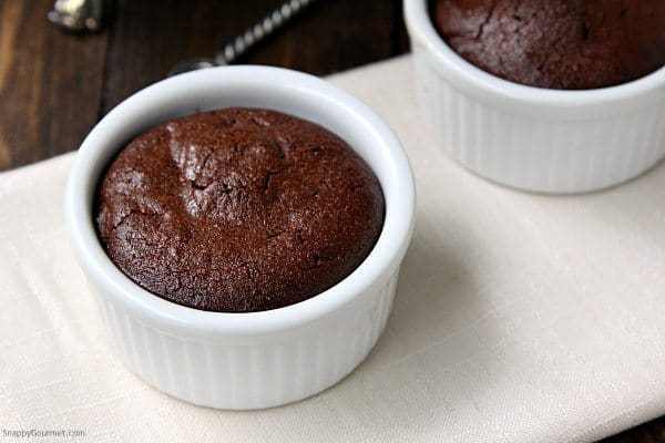 Mini almond flour chocolate cakes in white ramekins on white platter