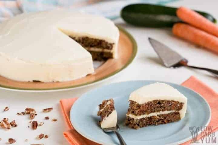 Slice of sugar free carrot cake on blue plate with piece of cake on fork.