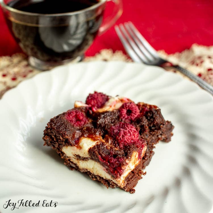 Dark Chocolate Raspberry Cheesecake Brownies on a white plate close up