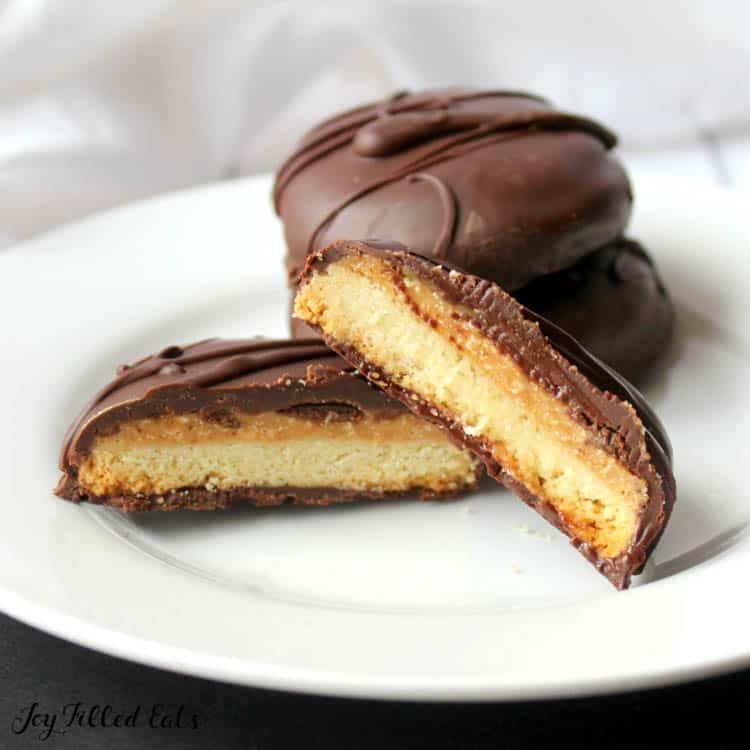 Tagalong cookies on plate with one cookie cut in half to see inside layers