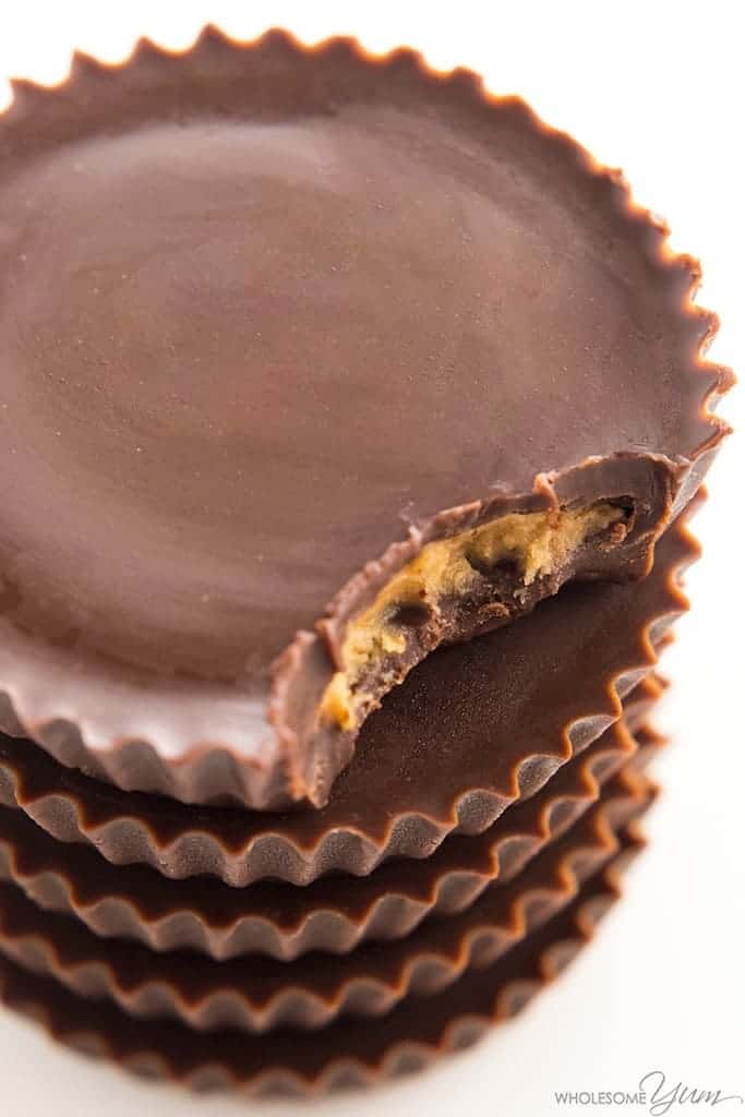 close up on stack of sugar free keto peanut butter cups with top piece missing a small bite