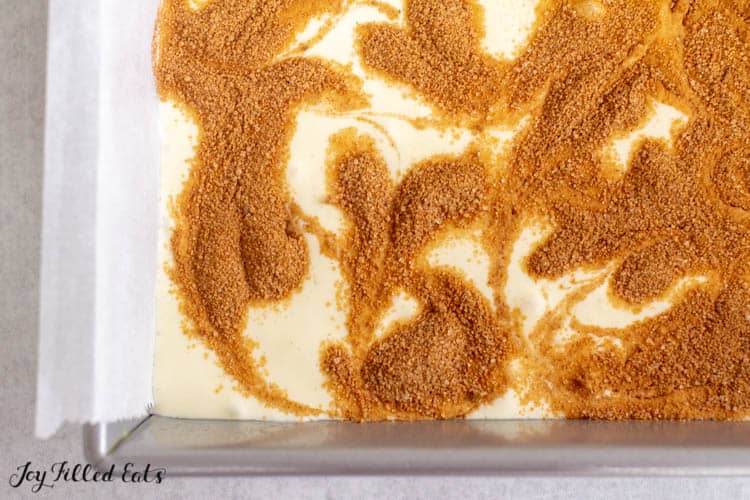 overhead shot of Cinnamon swirled into cheesecake batter before baking