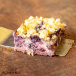 close up lemon blueberry cheesecake crumb bars on serving spatula