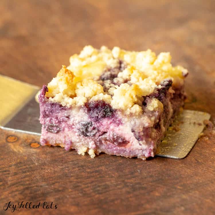 close up lemon blueberry cheesecake crumb bars on serving spatula