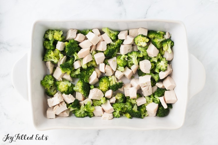 chicken and broccoli in a large white casserole dish