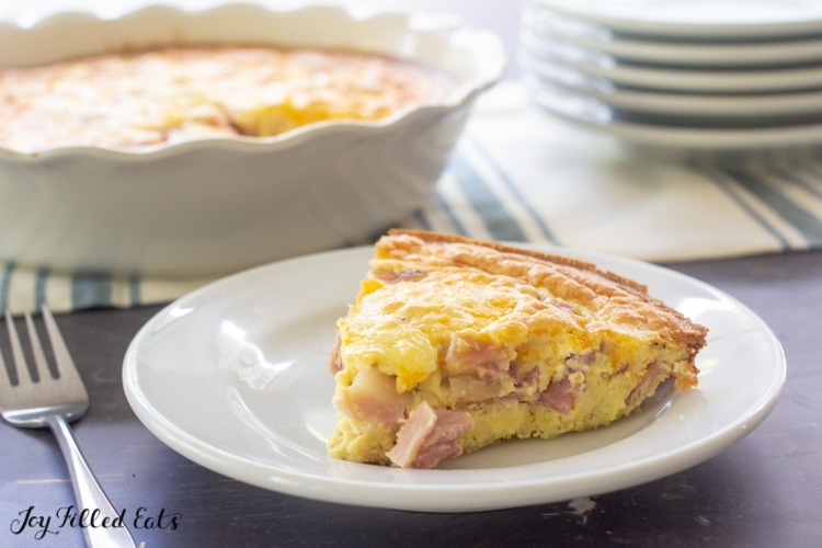 a slice of keto quiche with ham and cheese on a white plate