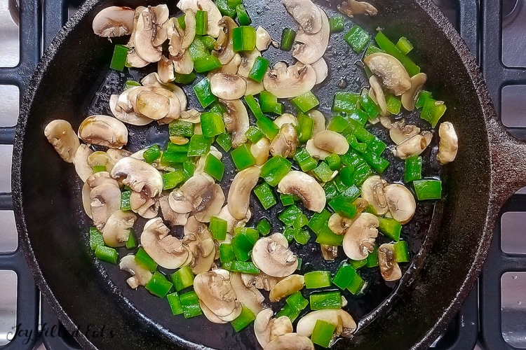 peppers and mushrooms in a large skillet for the meatza