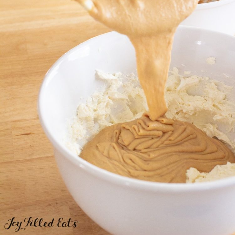 pb cheesecake batter being poured on top of whipped cream cheese