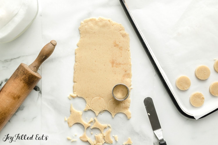 cookie dough with a rolling pin and round cookie cutter