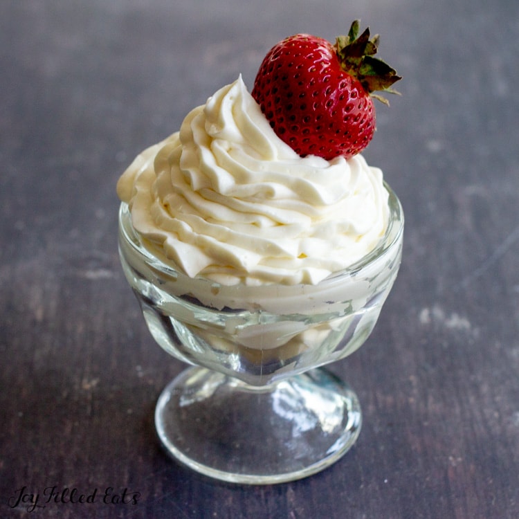 small bowl with keto cheesecake fluff topped with a strawberry