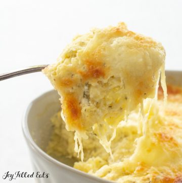 a spoon lifting up some keto spaghetti squash casserole with melted cheese