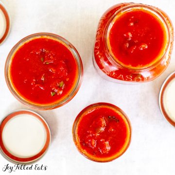3 mason jars of tomato sauce of varying sizes
