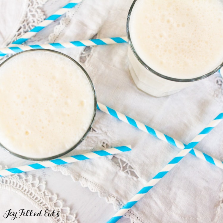 overhead shot of two glasses with Keto vanilla bean frappuccino with a bunch of striped straws