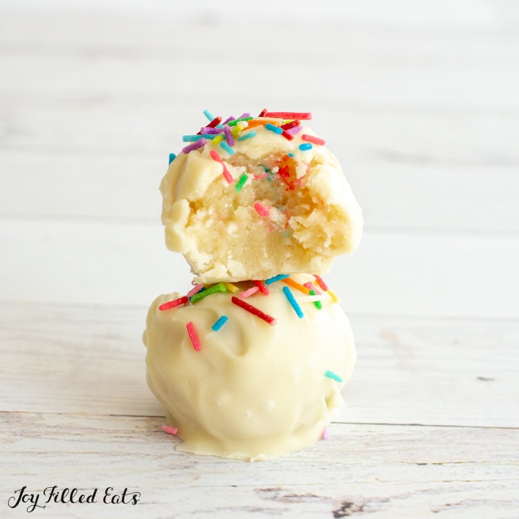 two cake batter truffles stacked on top of each other with a bite missing