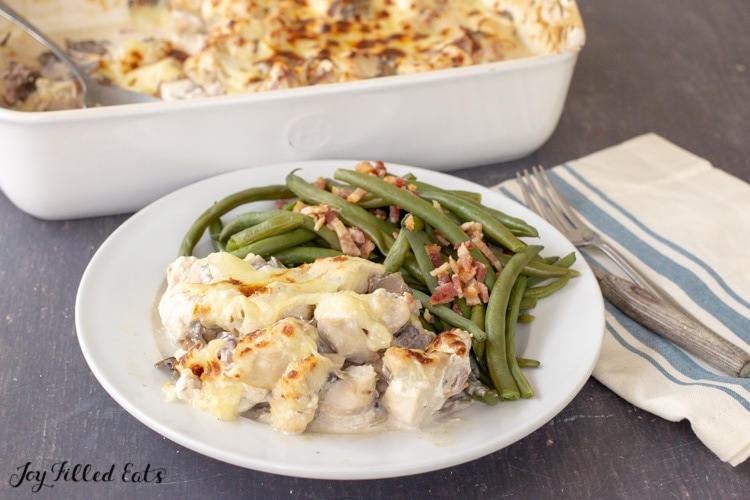 a dinner plate with chicken marsala bake and some green beans