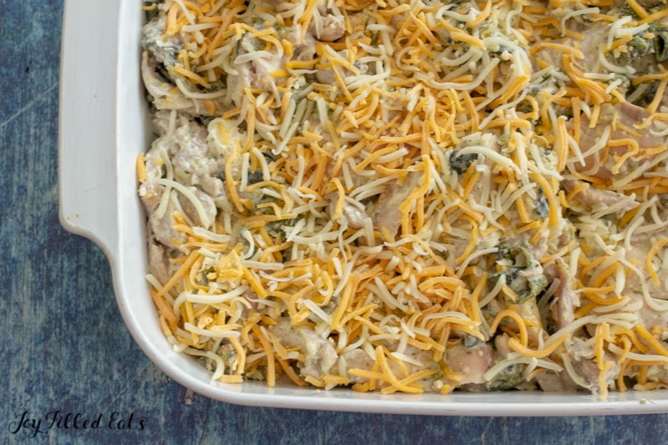 close up of the keto chile relleno casserole in a large casserole dish with shredded cheese