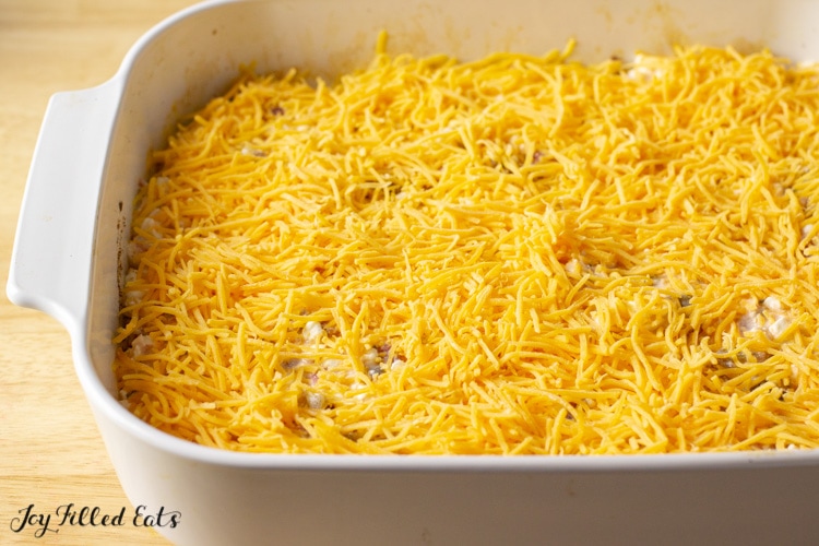 shredded cheese layered into casserole dish 