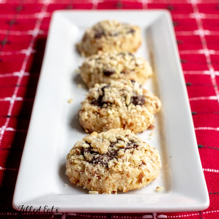 almond crunch chocolate thumbprint cookies lined on a rectangular white platter
