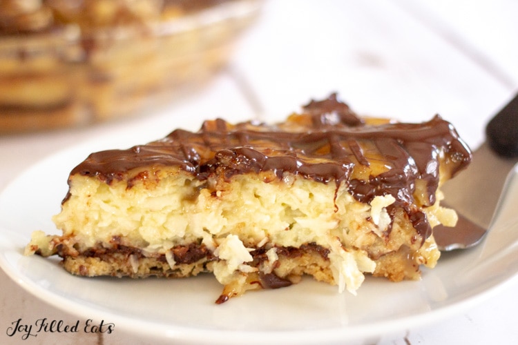 slice of chocolate caramel Samoas coconut pie laying on a serving spatula laying on a white plate