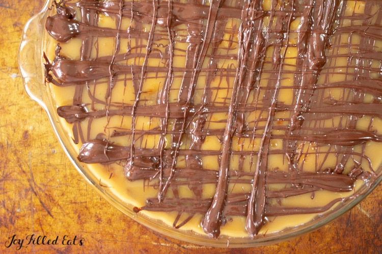 chocolate drizzled on top of the caramel coconut cream pie