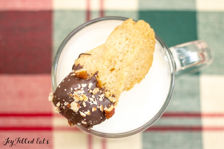 one of the keto shortbread cookies resting on a glass of milk