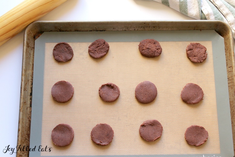 circles of cookie dough on a baking mat
