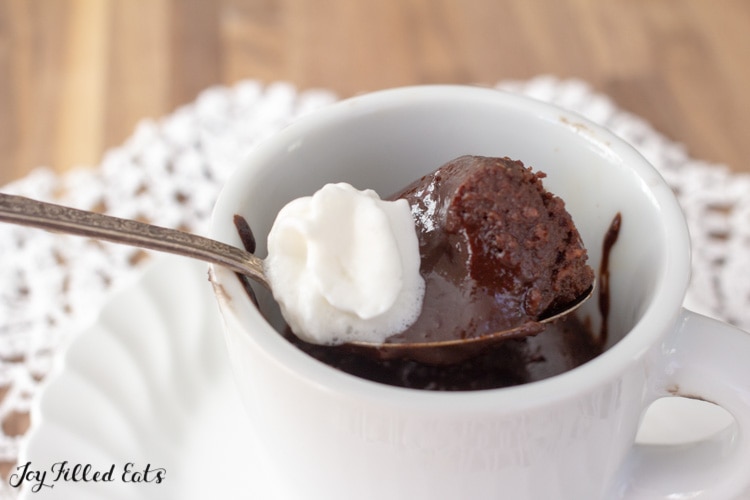 a spoon with lava cake and whipped cream