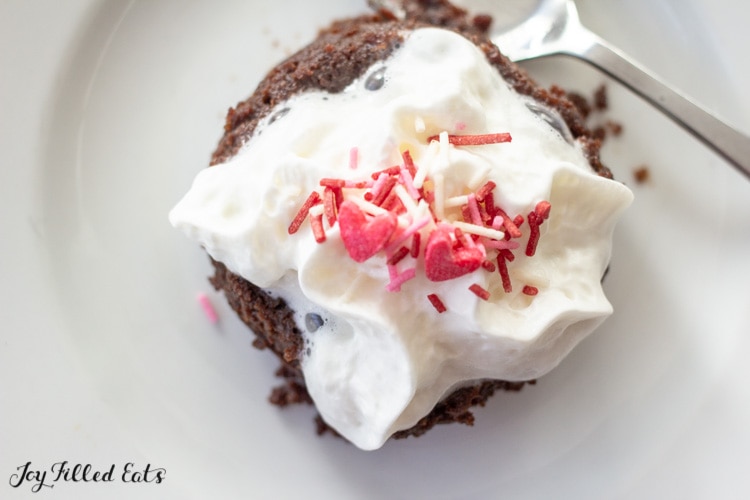 chocolate cake topped with whipped cream and heart sprinkles