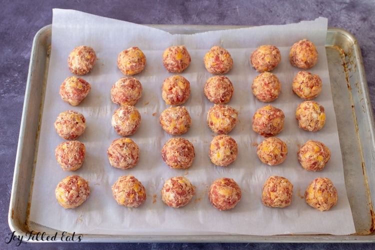 a baking sheet lined with parchment with 30 keto sausage balls