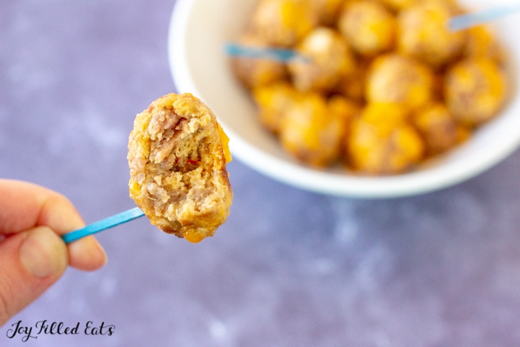 a hand holding up one of the appetizer bites with a bite missing