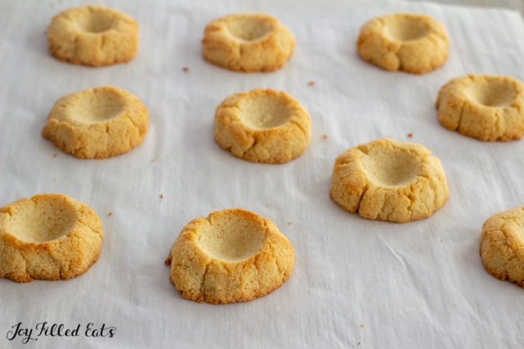 shortbread cookies on a baking sheet with wells in the centers