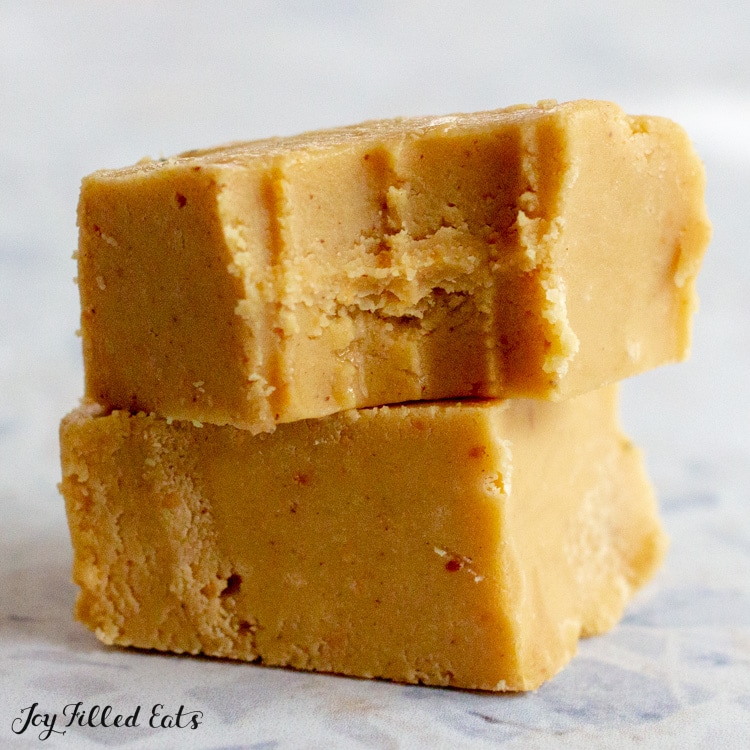 close up of two pieces of keto peanut butter fudge stacked, top piece missing a bite