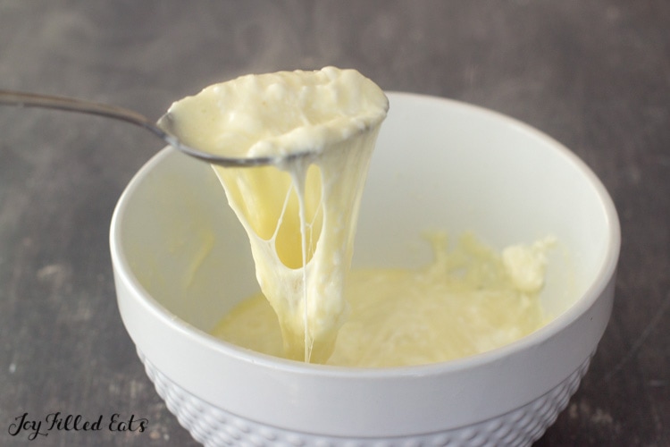 a spoon lifting up melted mozzarella cheese
