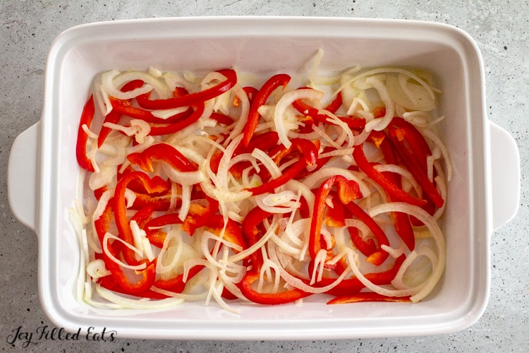 raw peppers and onions in casserole dish