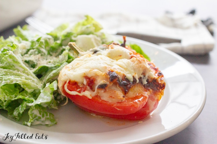 one of the chicken parm stuffed pepper on a plate with a salad