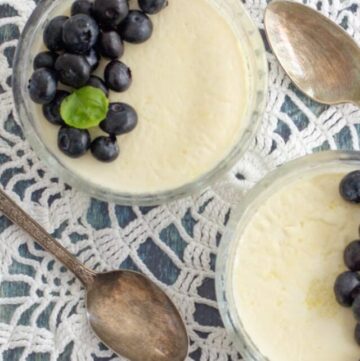 two small dishes of keto panna cotta topped with blueberries