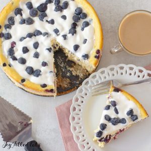 overhead shot of the keto blueberry cheesecake with a piece on a small plate