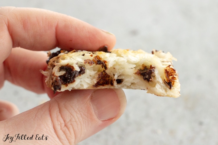a hand holding one of the low carb coconut bars