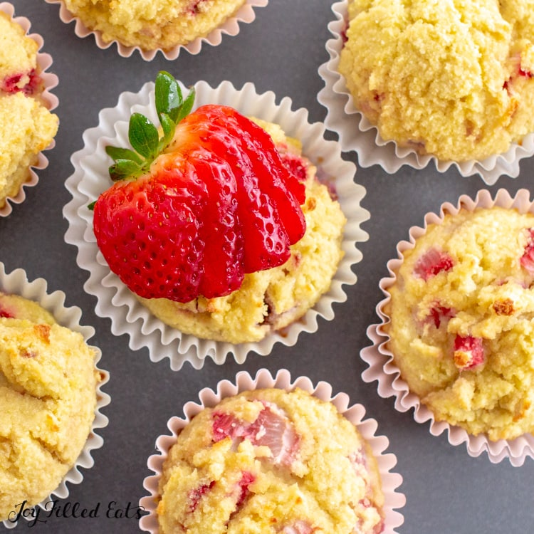 overhead shot of keto strawberry muffins with a sliced strawberry fanned out on top of one