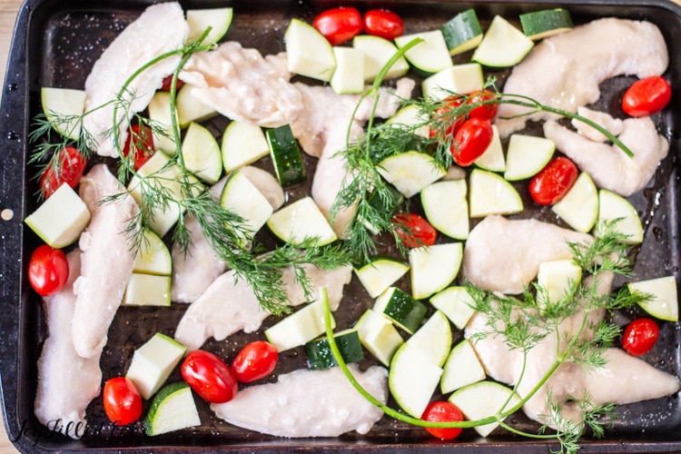 sheet pan with frozen chicken tenderloins and vegetables