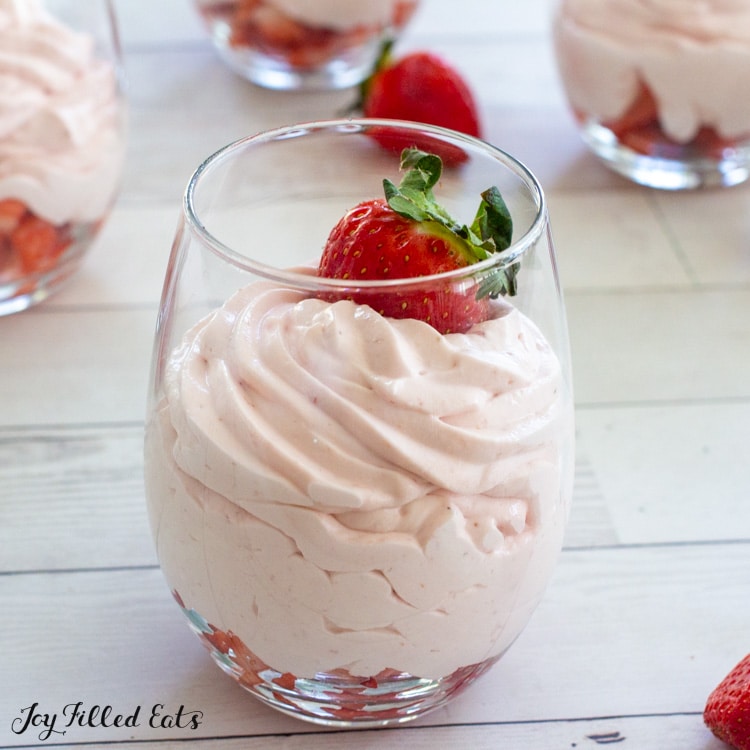 keto strawberry mousse in a wine glass with a strawberry