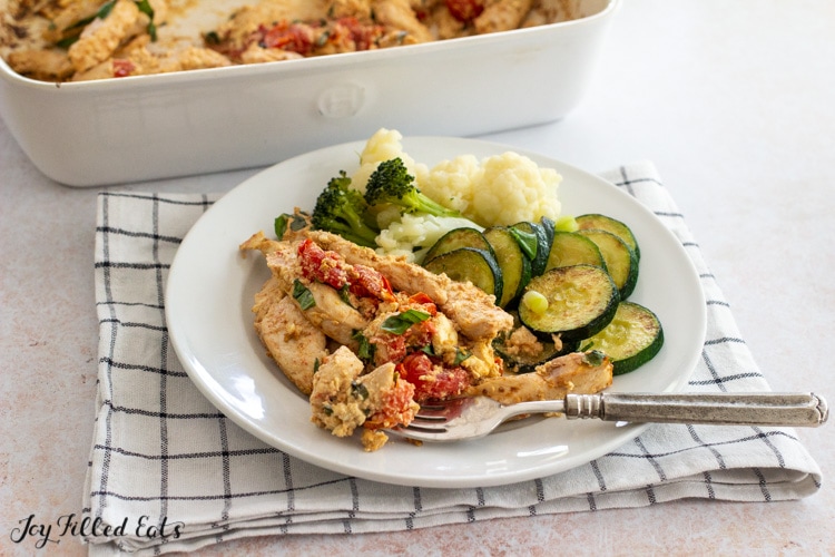 plate with baked feta chicken and vegetables
