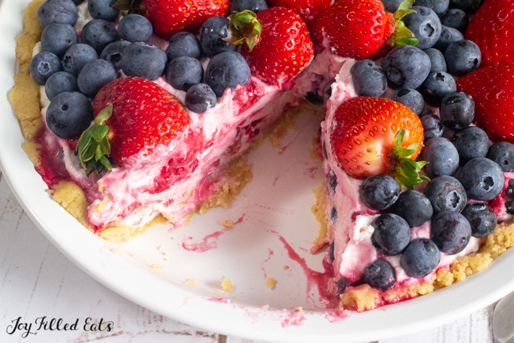 close up of cut cottage cheese cheesecake topped with berries