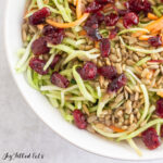 close up of keto broccoli slaw topped with cranberries and sunflower seeds