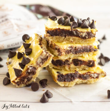 stack of keto chocolate chip cheesecake bars and bags of chocolate chips
