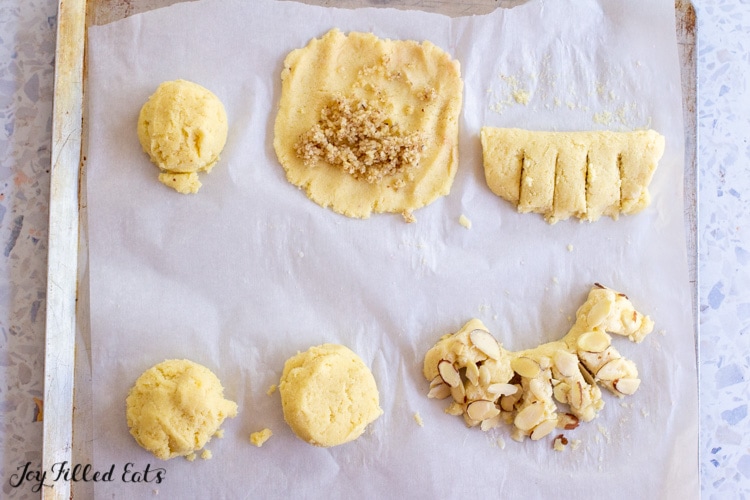 balls of dough, flattened dough, and filled dough on a parchment lined cookie sheet