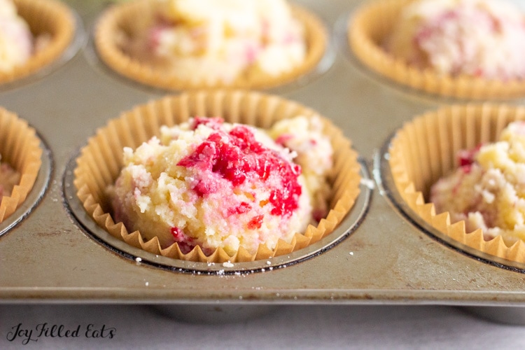 batter for the keto raspberry muffins in a cupcake tin