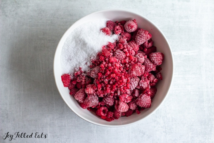 bowl of frozen raspberries and sweetener
