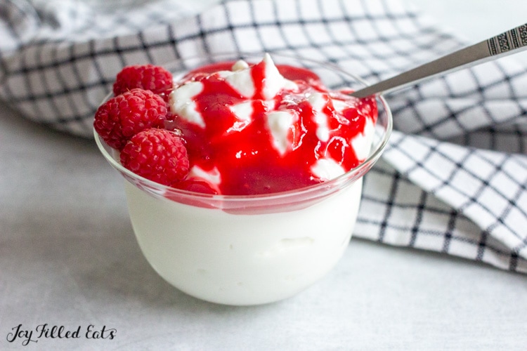 small bowl of yogurt with raspberries and keto raspberry sauce