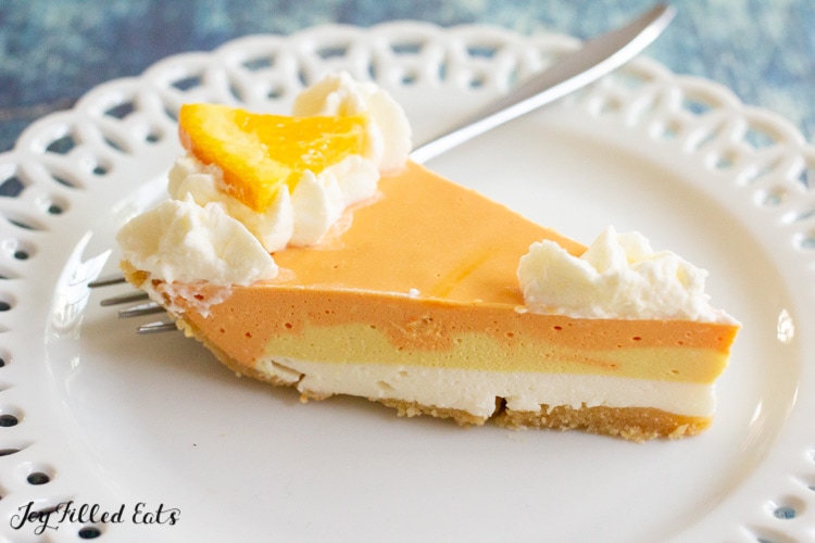 slice of orange creamsicle cheesecake on a plate with a fork